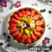Exquisite French Fruit Tart 42 Tarte aux Fruits on a white board, surrounded by flowers.