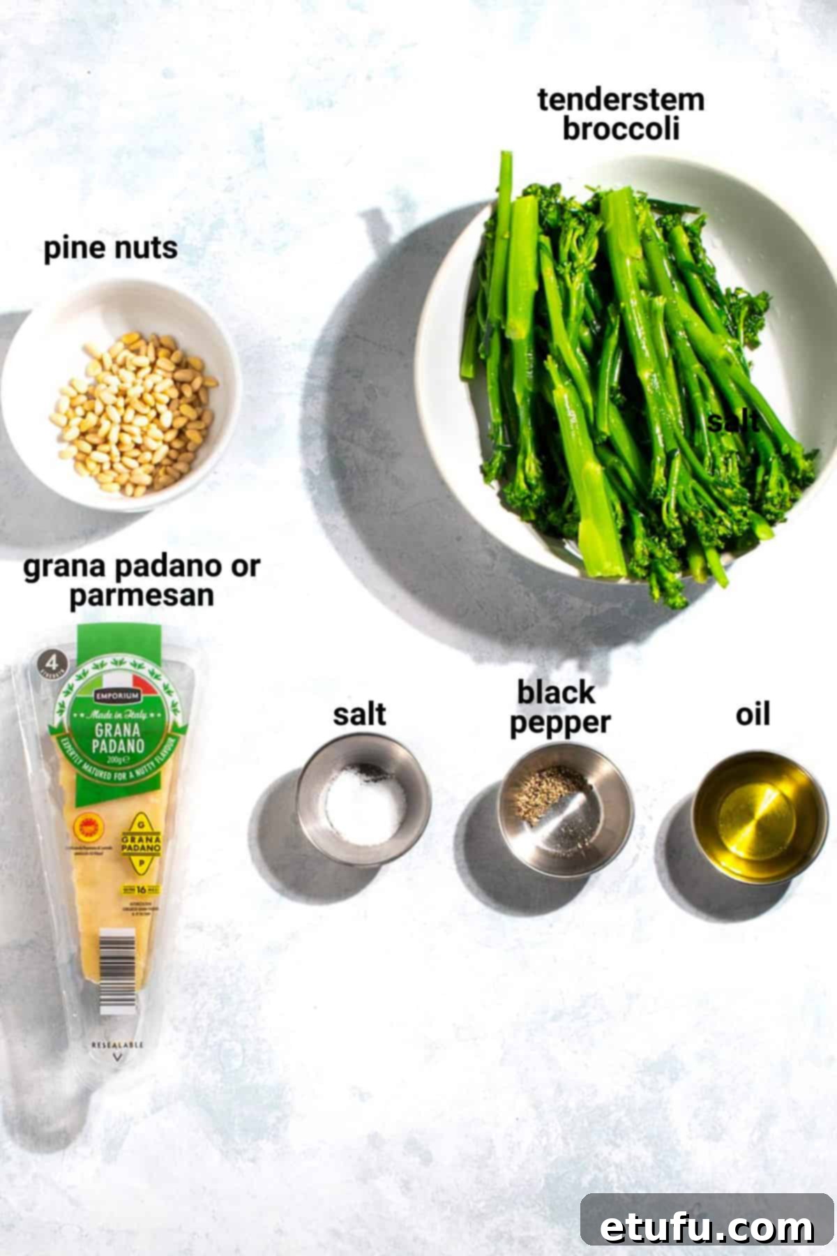 Fresh ingredients for roasted tenderstem broccoli including olive oil, parmesan, pine nuts, salt, and pepper.