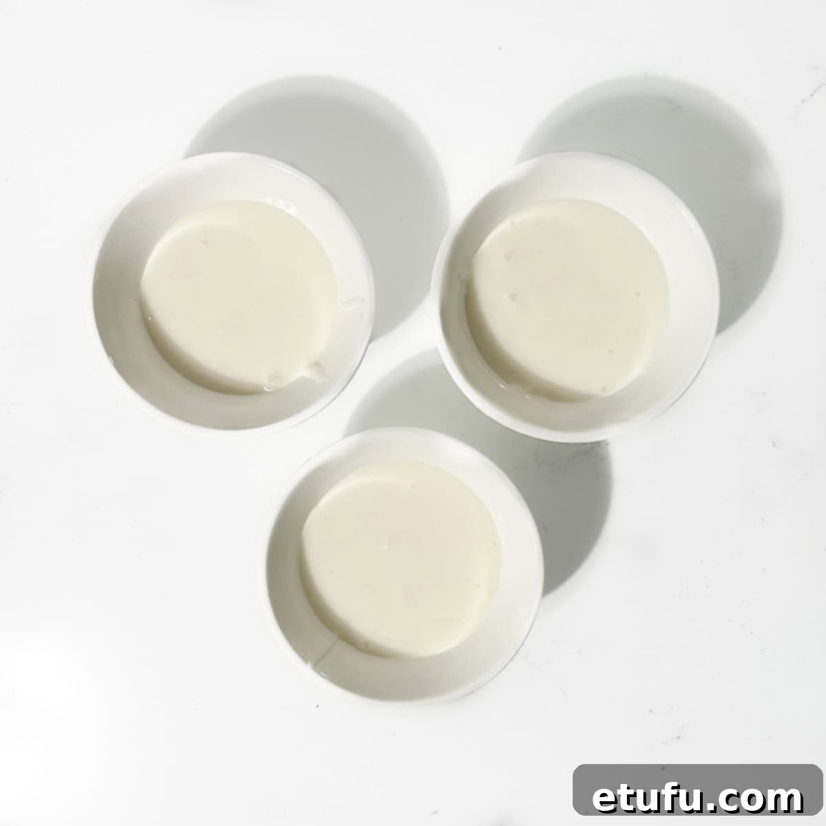 Three small bowls of white icing.