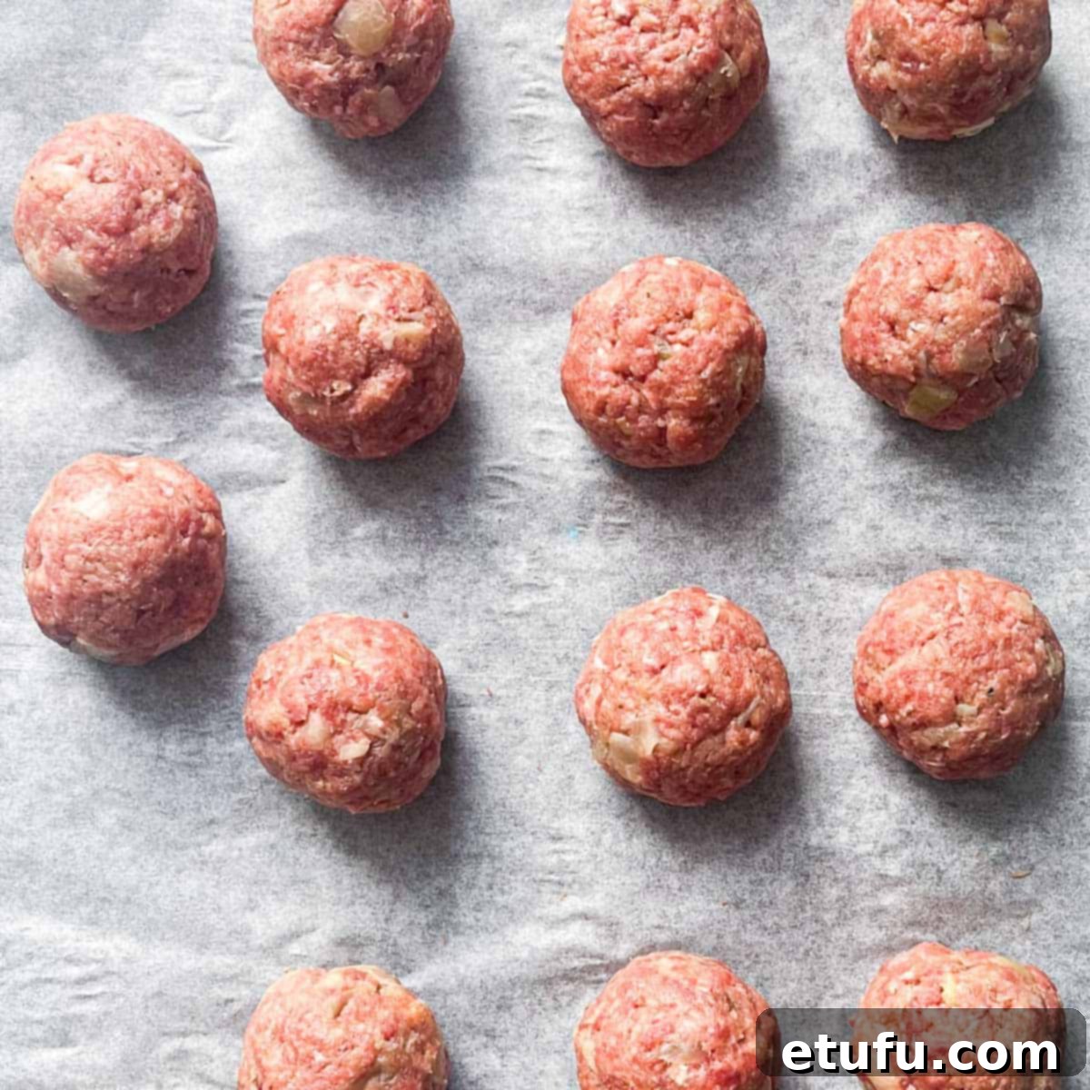 Lihapullat meatballs rolled and placed onto a lined baking tray.