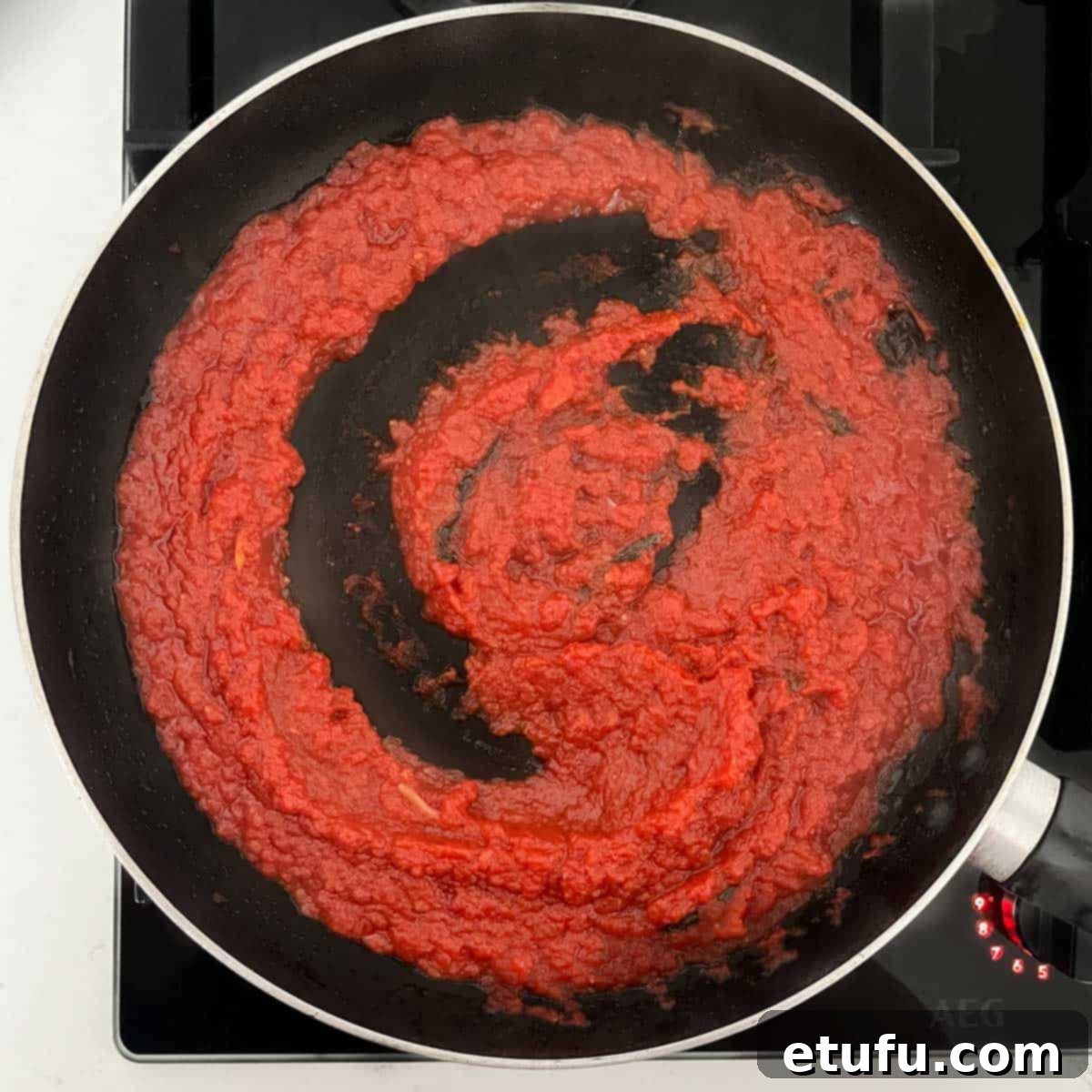 The cooked sauce for pasta alla sorrentina in a black frying pan.