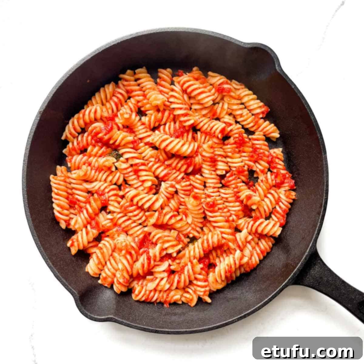 A thin layer of pasta and sauce added to a cast iron pan.