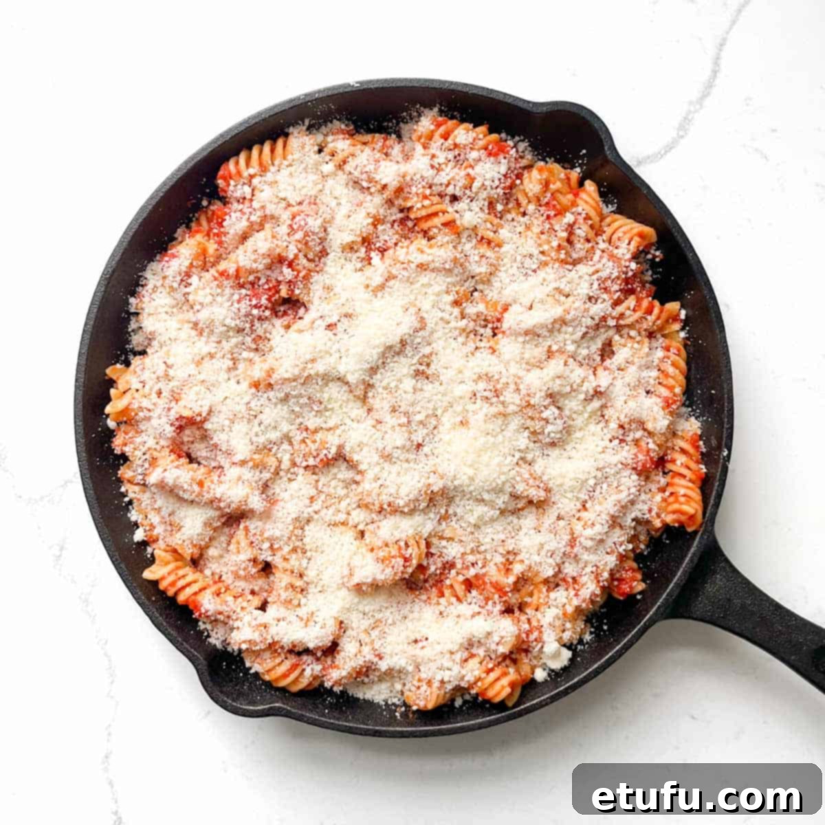 The final layer of parmesan added on top of the pasta alla sorrentina.
