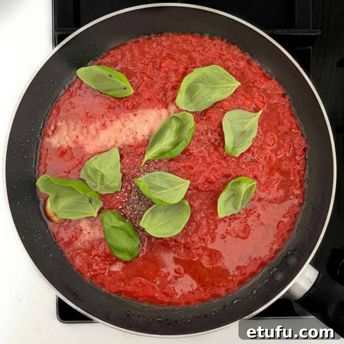 All the ingredients for the tomato sauce added to a frying pan.