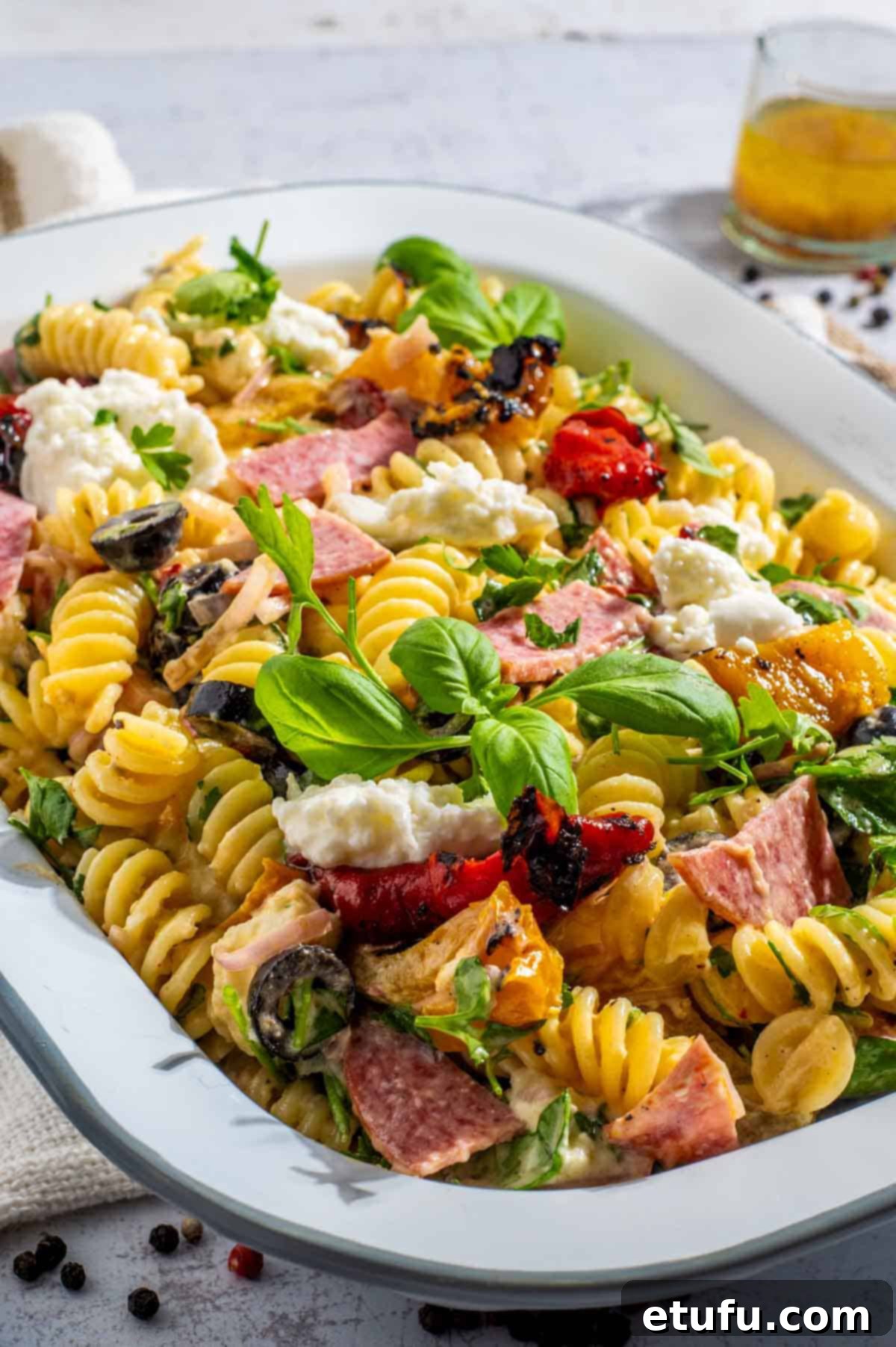 Creamy italian pasta salad in a rectangular enamel bowl.