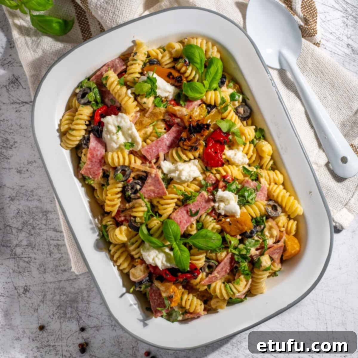 Creamy italian pasta salad in a rectangular enamel bowl.
