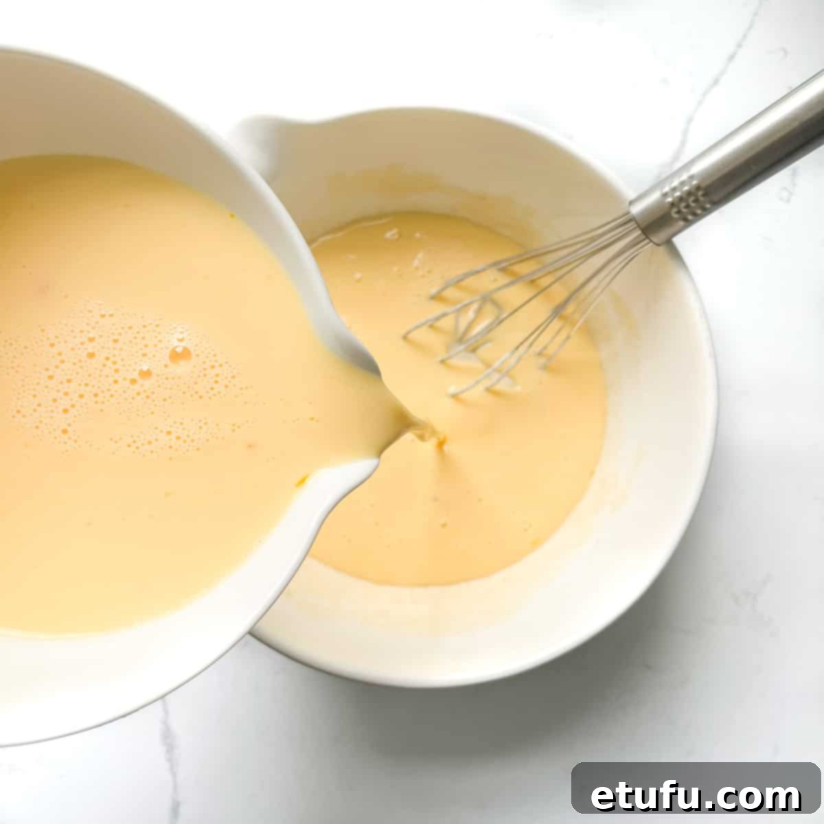 Pouring the milk and egg mixture into the rest of pandekager batter.
