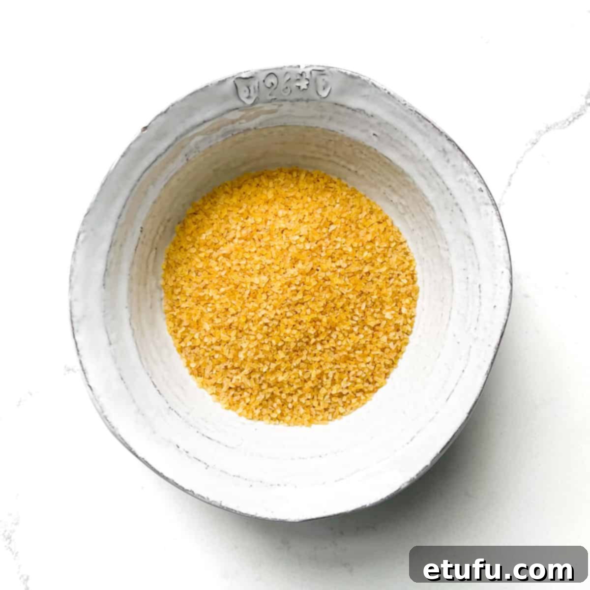 Dry bulgur wheat in a white bowl. 