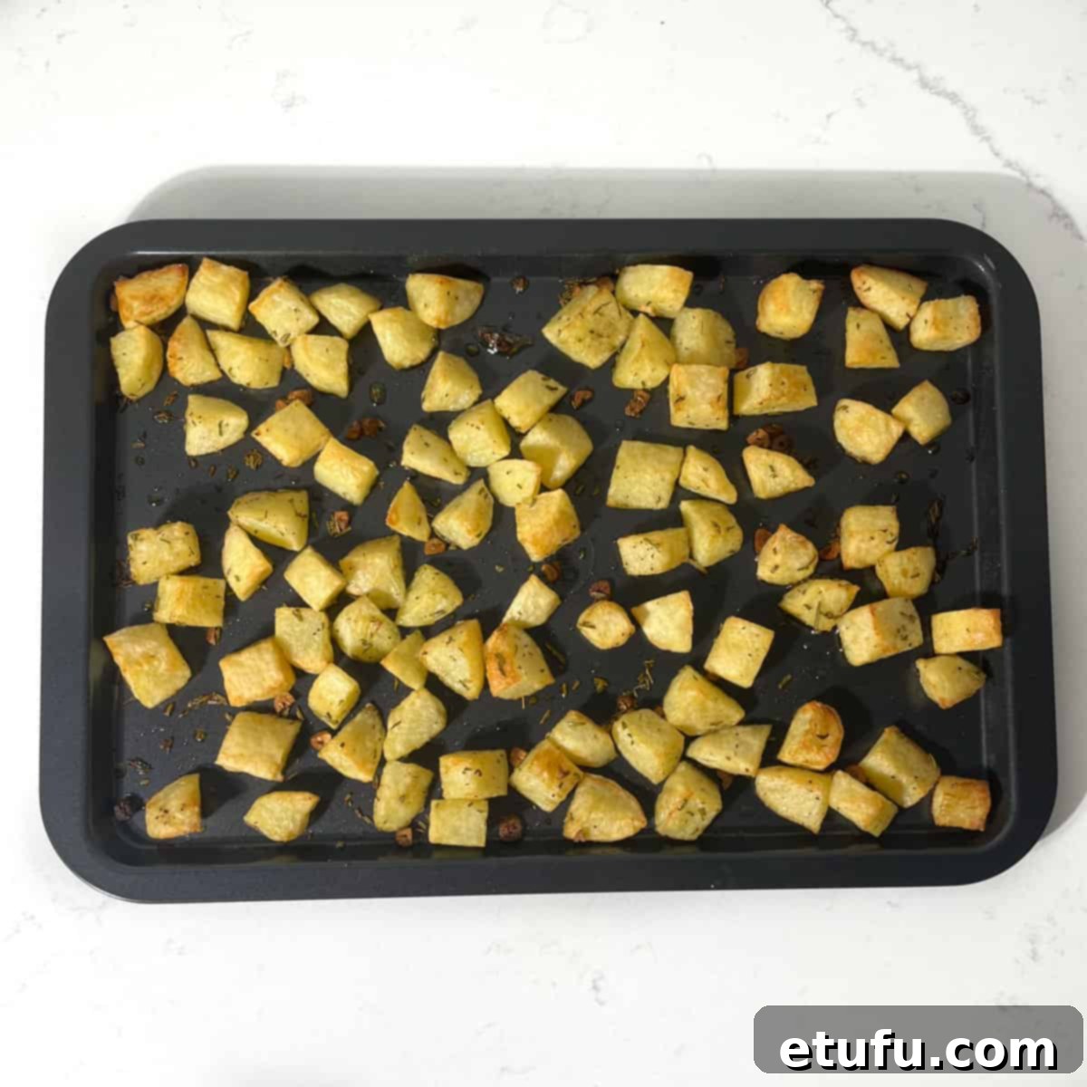 Roasted parmentier potatoes on a baking tray.