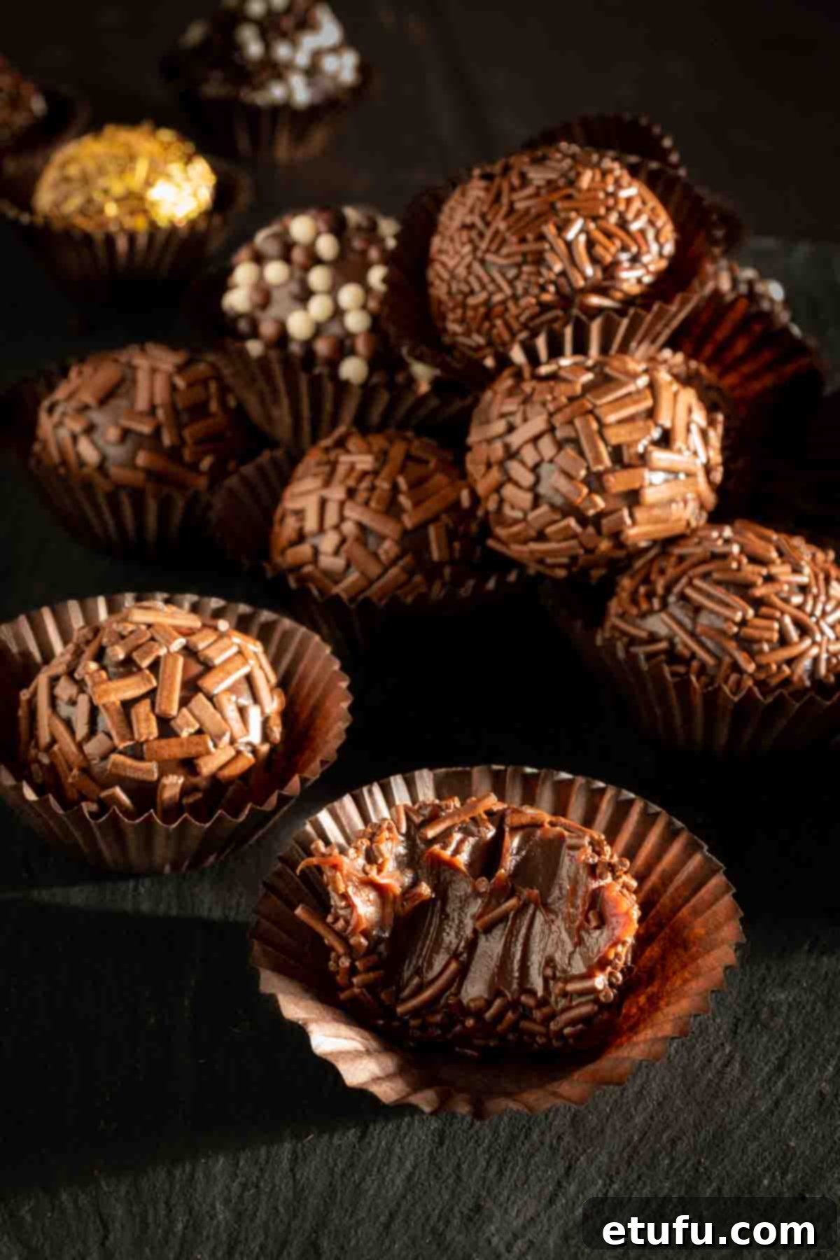 Brigadeiros in paper cases with various toppings.