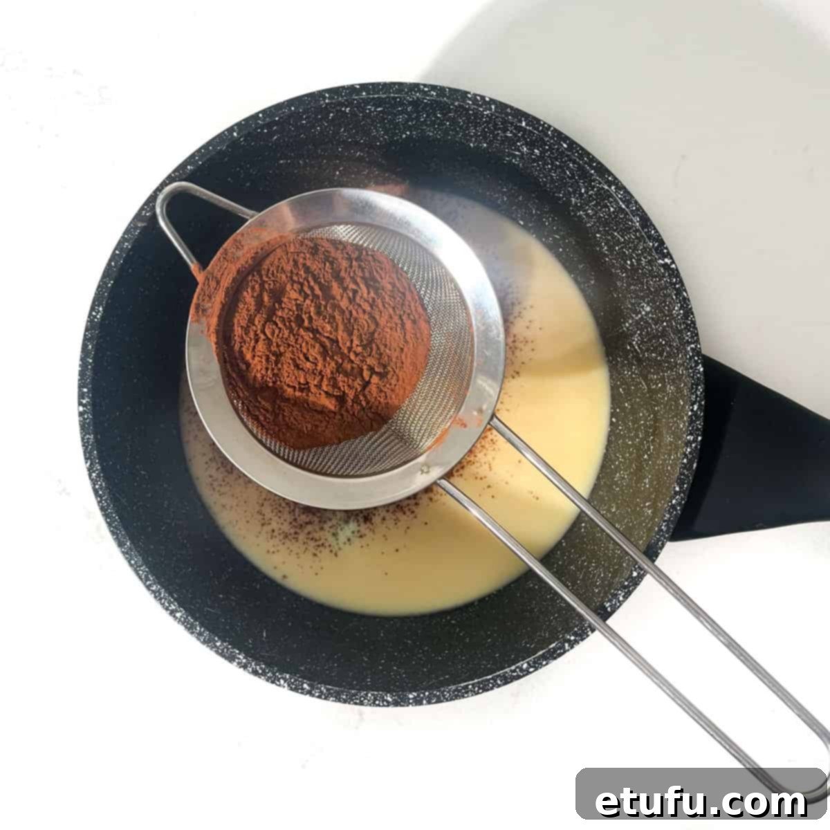 Sifting the cocoa powder into the condensed milk.