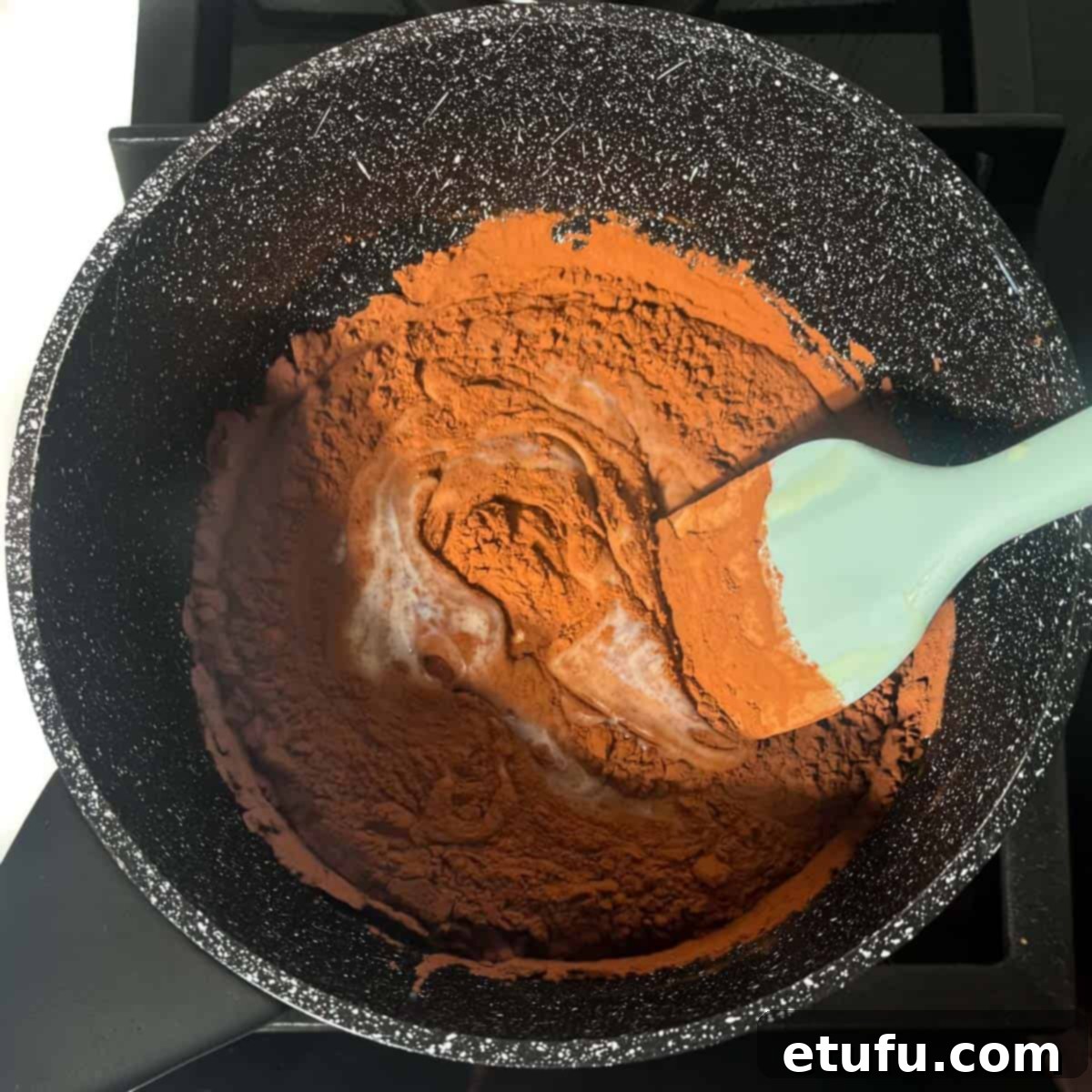 Stirring all the ingredients together for the brigadeiros in a medium saucepan.