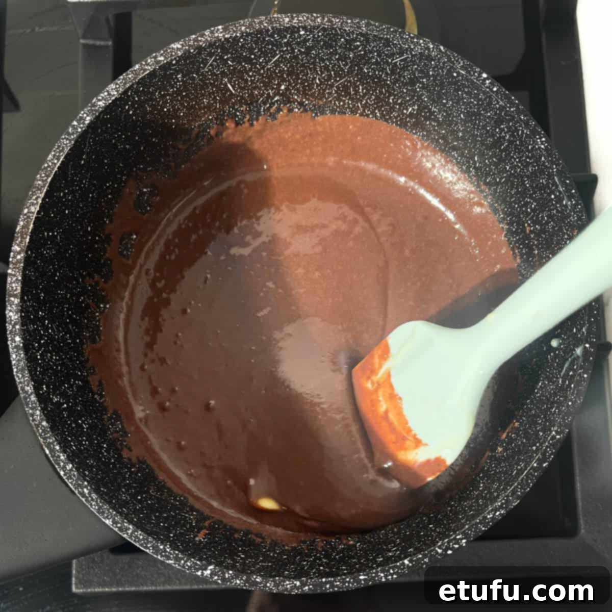 Stirring the brigadeiro mixture to melt the butter.