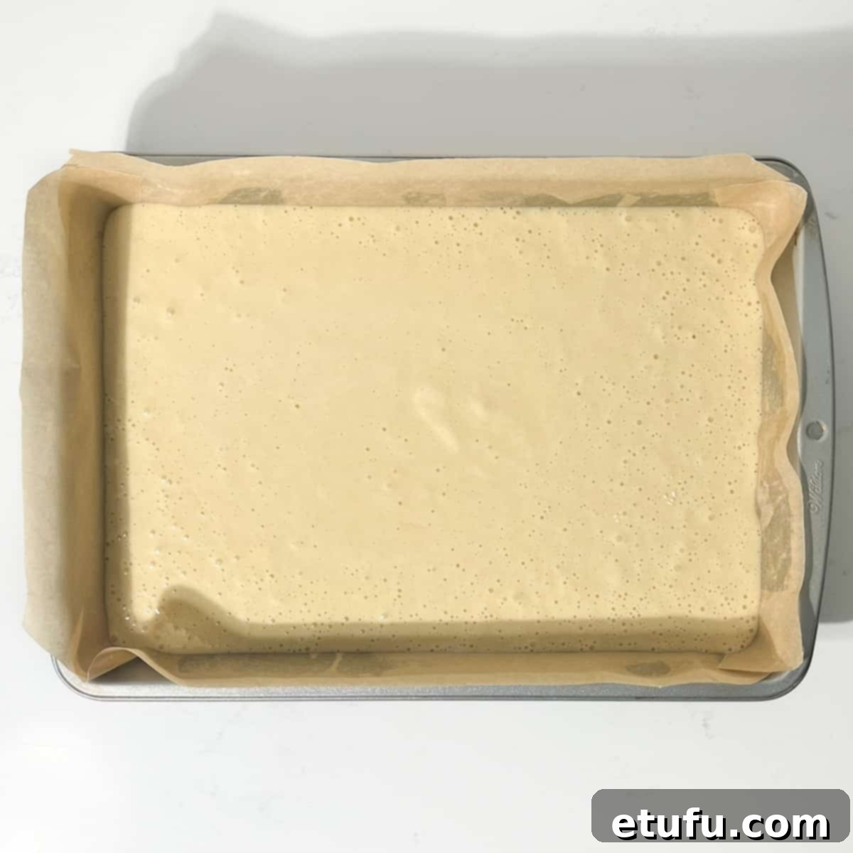 The batter for the vanilla tray bake in a rectangular baking tin.