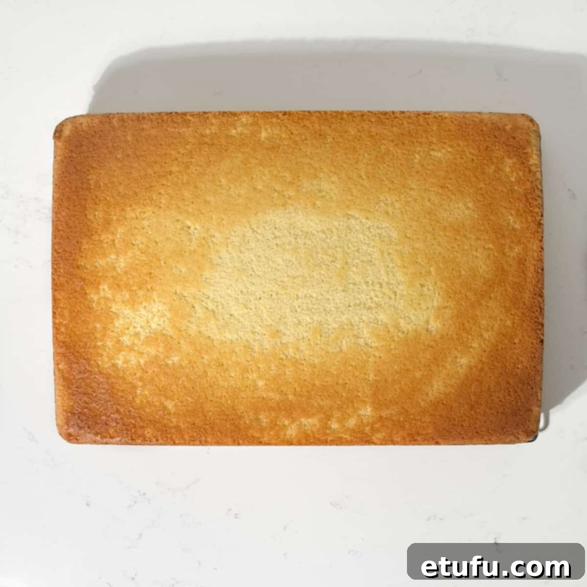 Removing the parchment paper from the cake.