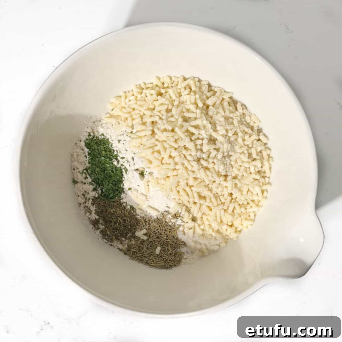 Adding all the ingredients for the dumplings to a large white bowl.