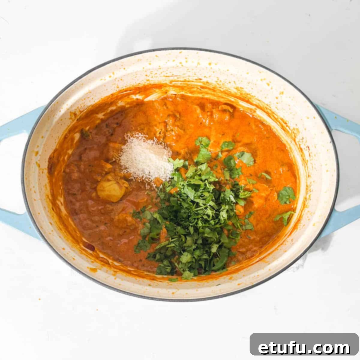 Adding the chopped coriander and desiccated coconut to the Chicken Handi.