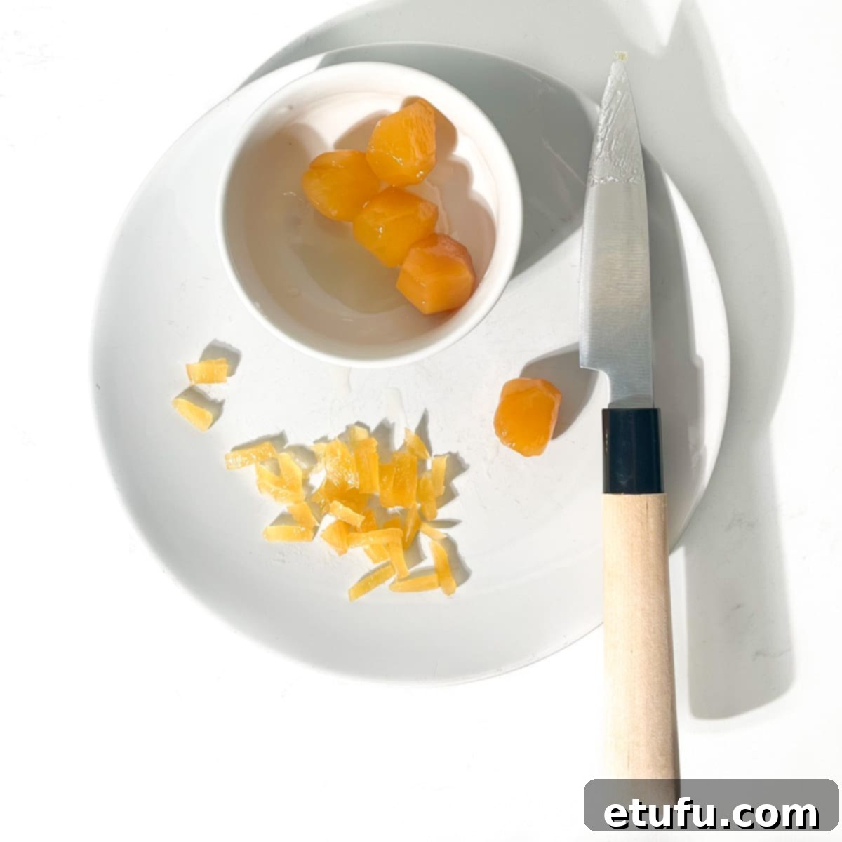 Chopping up stem ginger on a white plate for the jamaican ginger cake. 