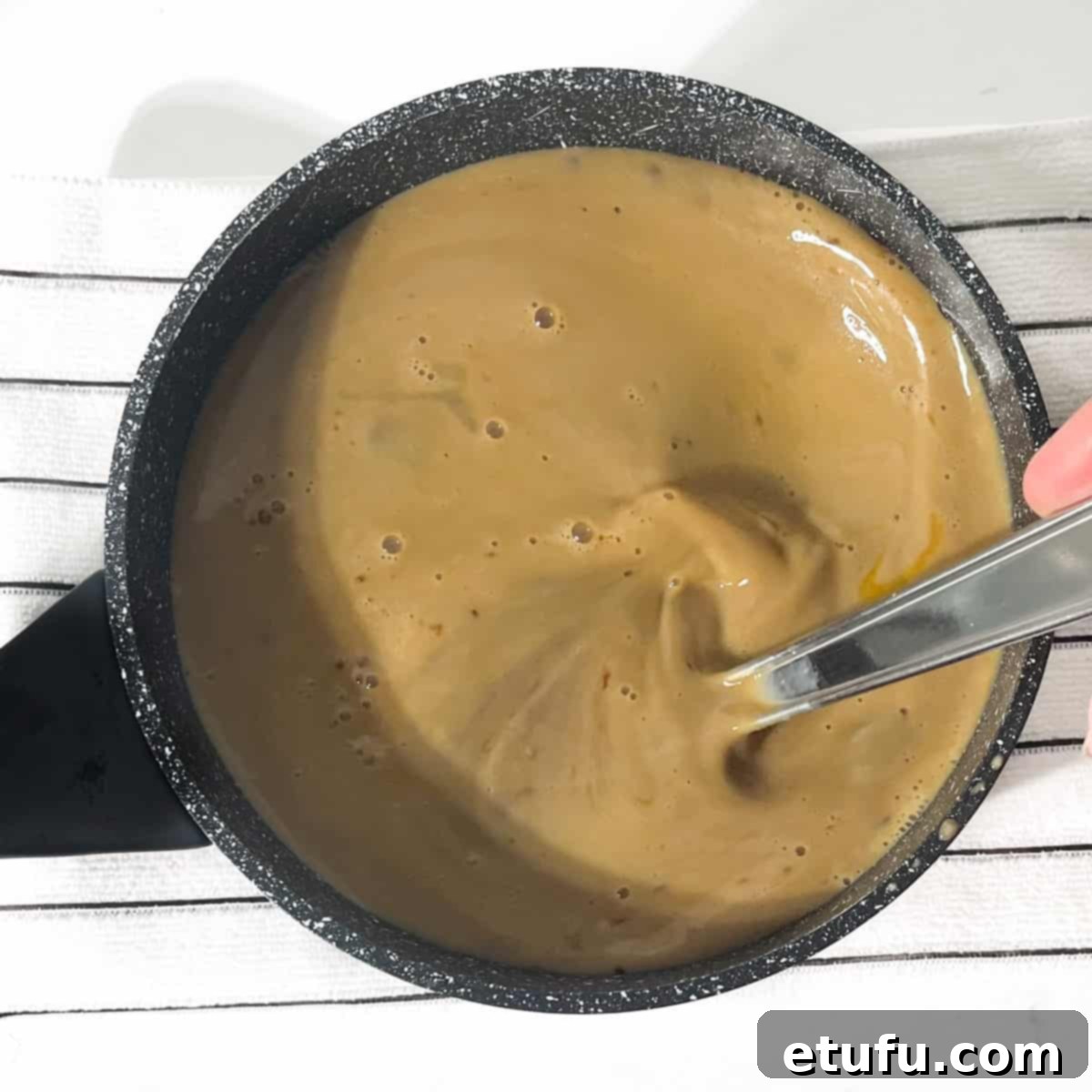 Whisking the milk and eggs into the melted liquids for the Jamaican ginger cake.