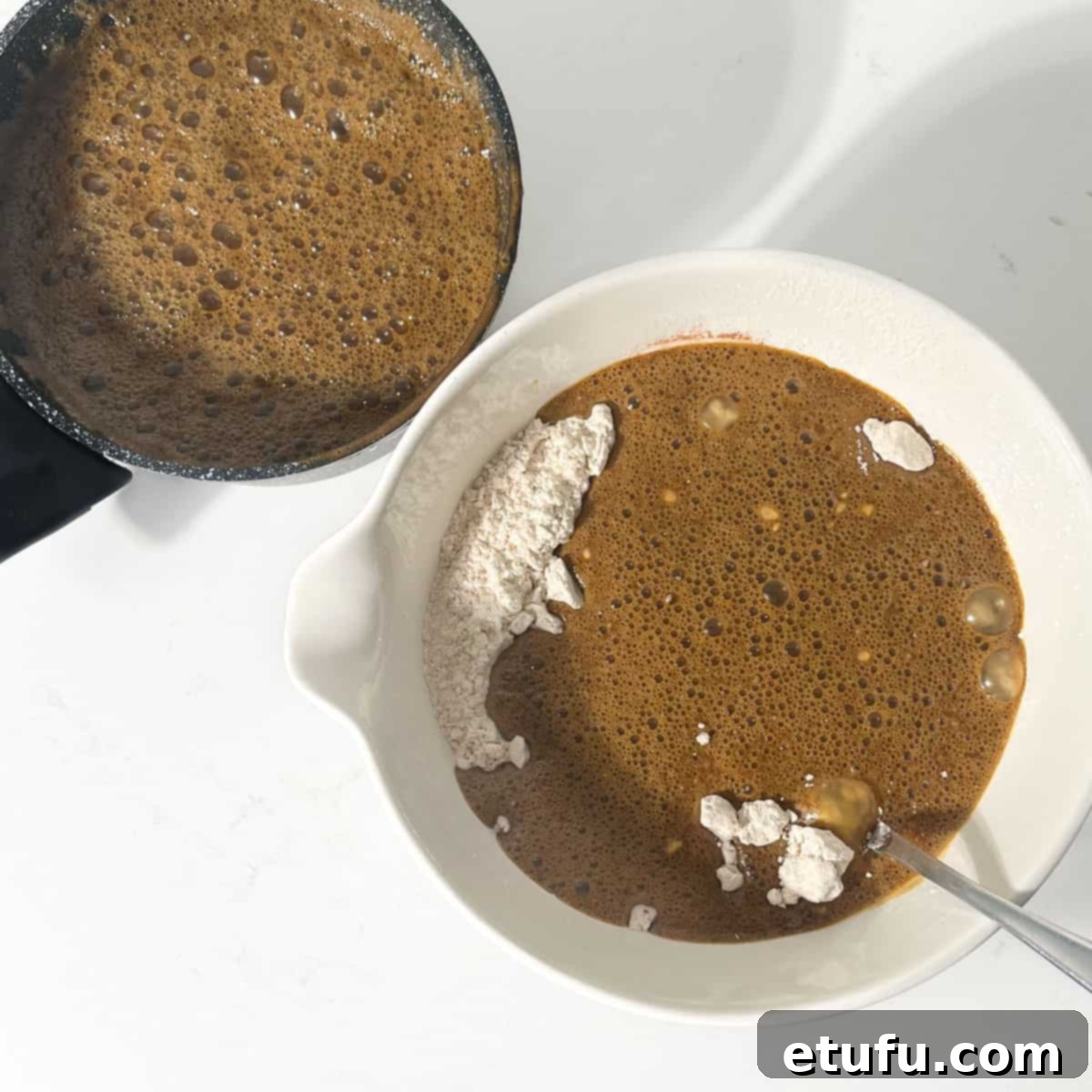 Gradually adding the liquids to the flour in a large mixing bowl.