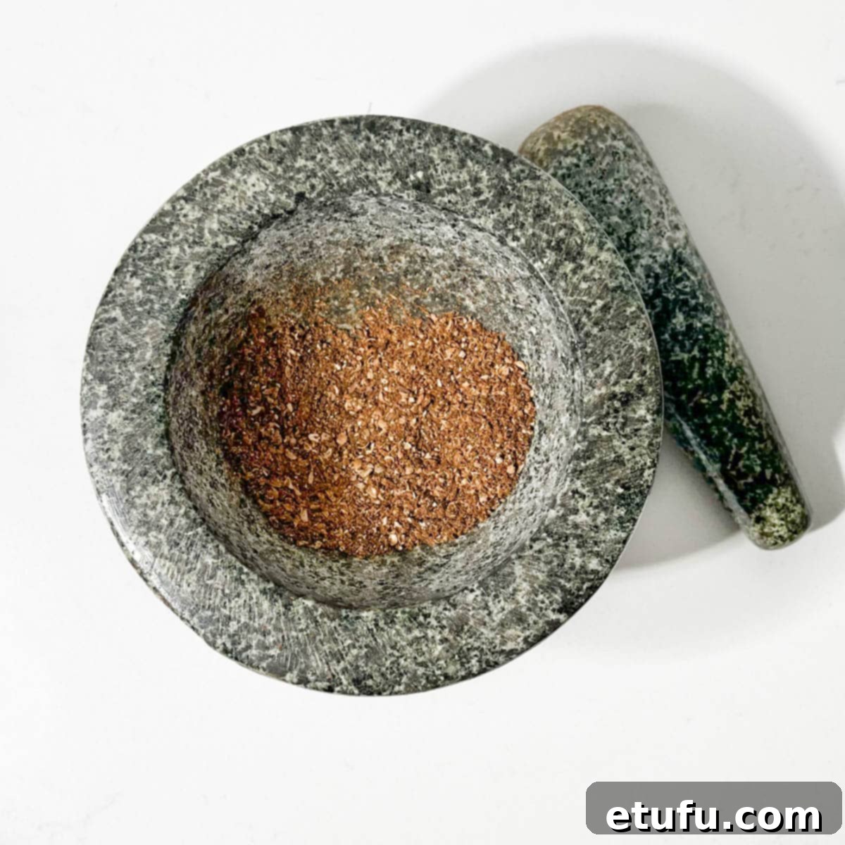 Toasted spices for chutney ground down in a mortar and pestle.