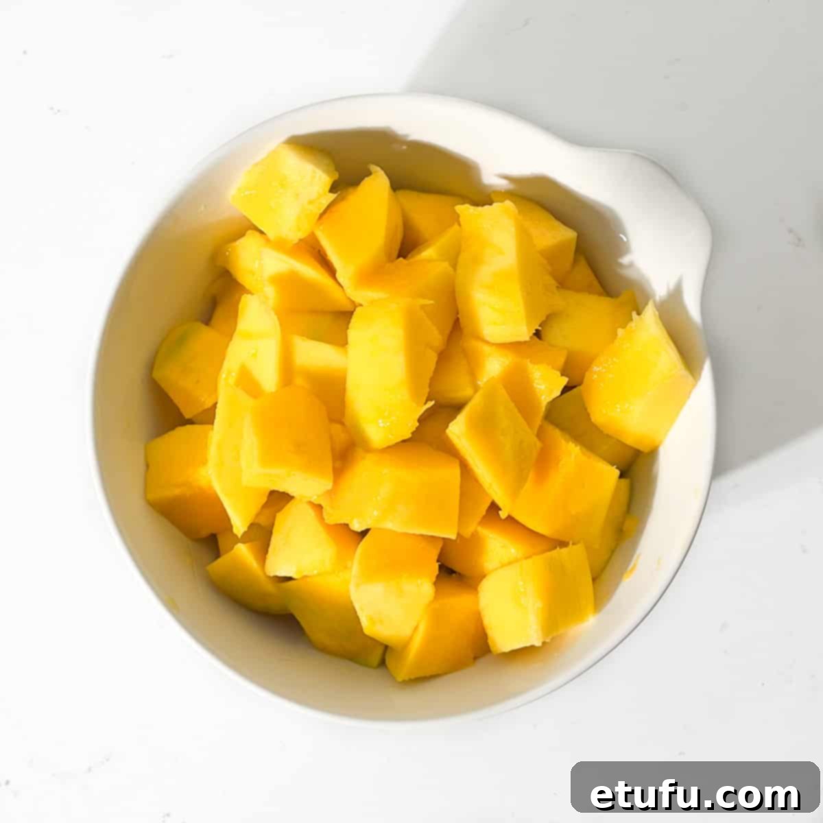 Diced mango in a large white bowl for the Indian mango chutney.