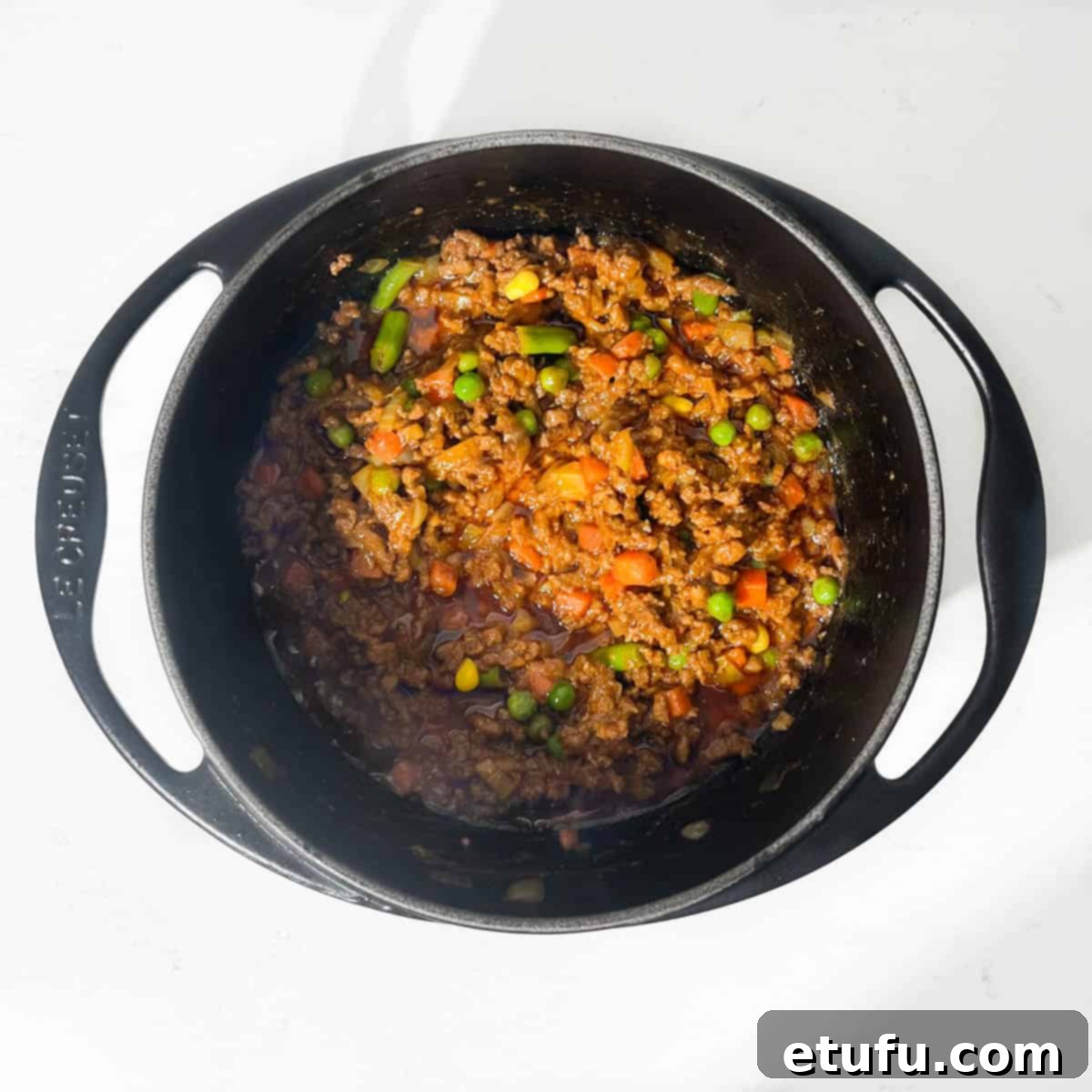 Cooked curried mince in a black saucepan.