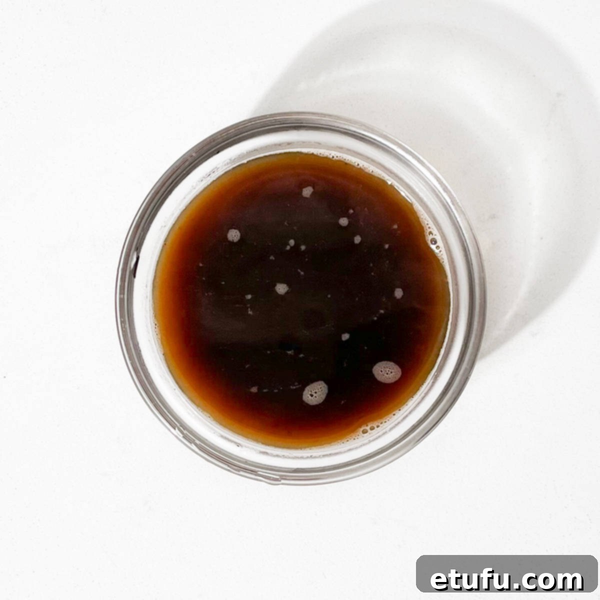 Beef stock in a small glass bowl.