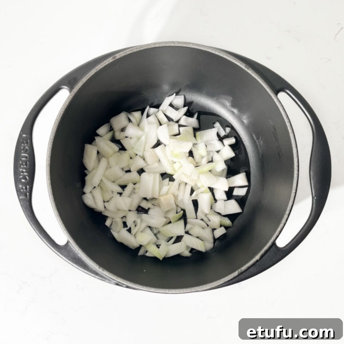 Diced onions in a black saucepan.