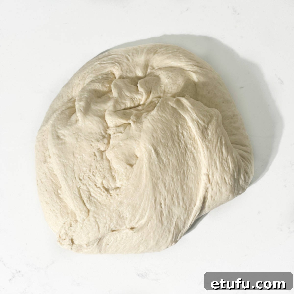 Dough turned out on a kitchen counter.