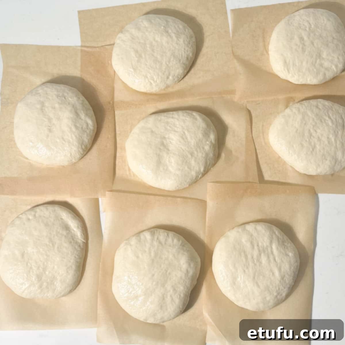 Portions of dough on individual pieces of baking paper.