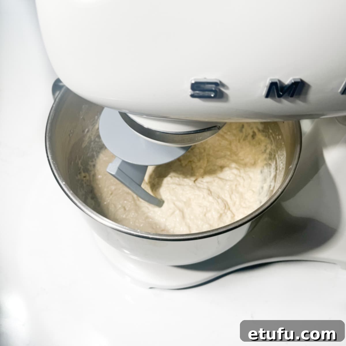 A stand mixer mixing the vetkoek dough.