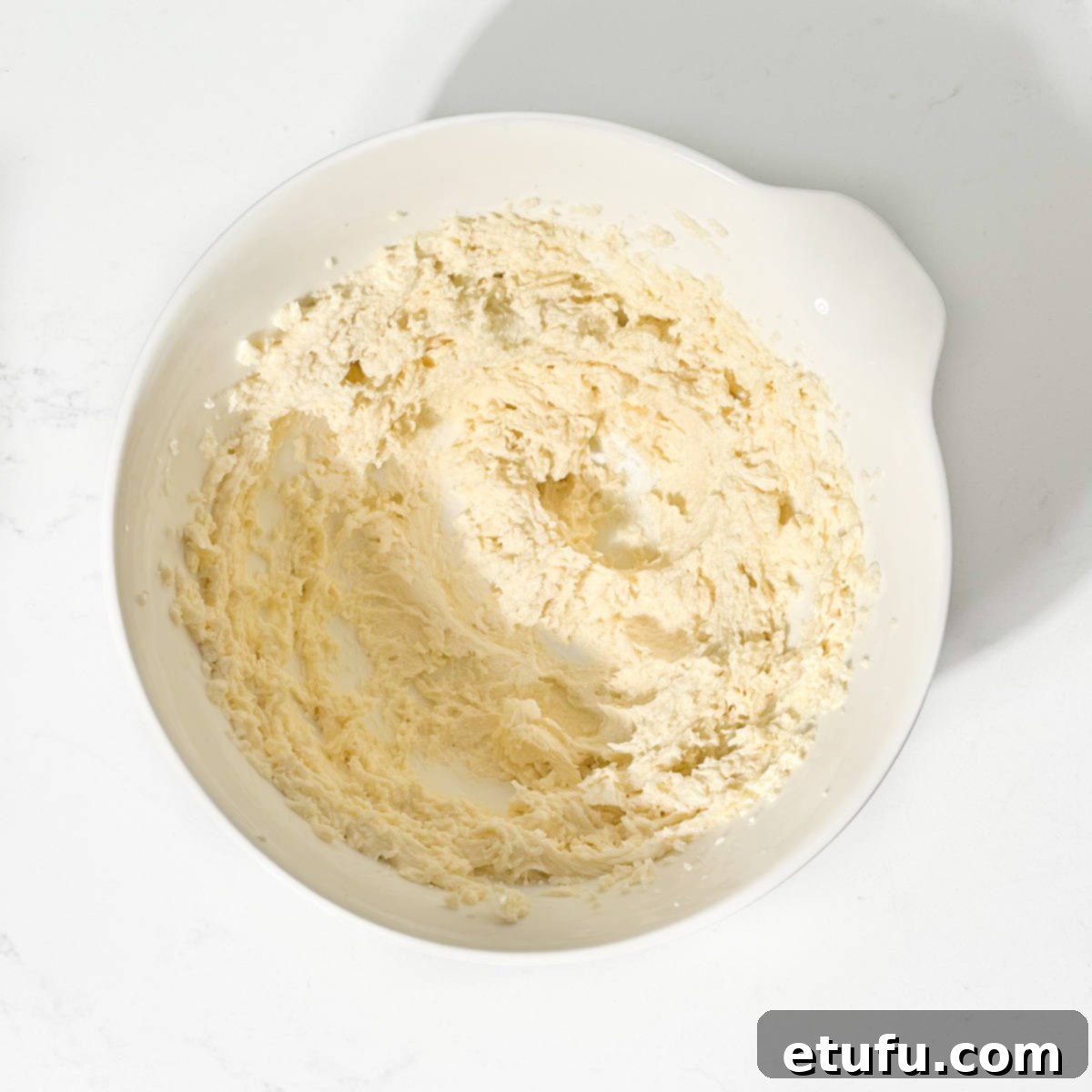 Smooth, creamy frangipane batter in a white mixing bowl, ready to be spread.