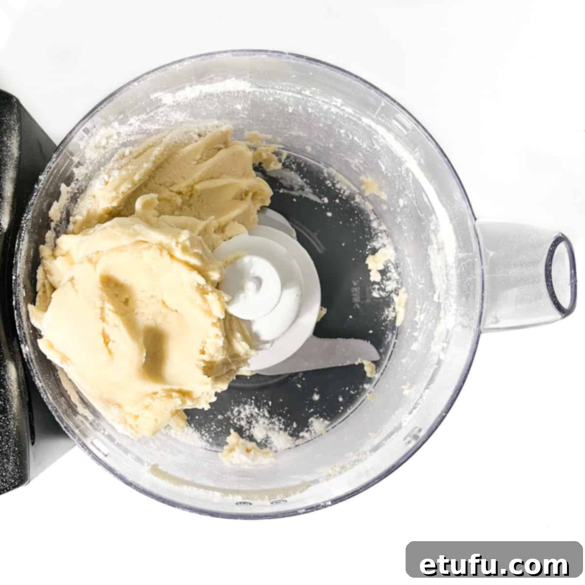 A ball of perfectly formed pastry dough in a food processor, ready for chilling.