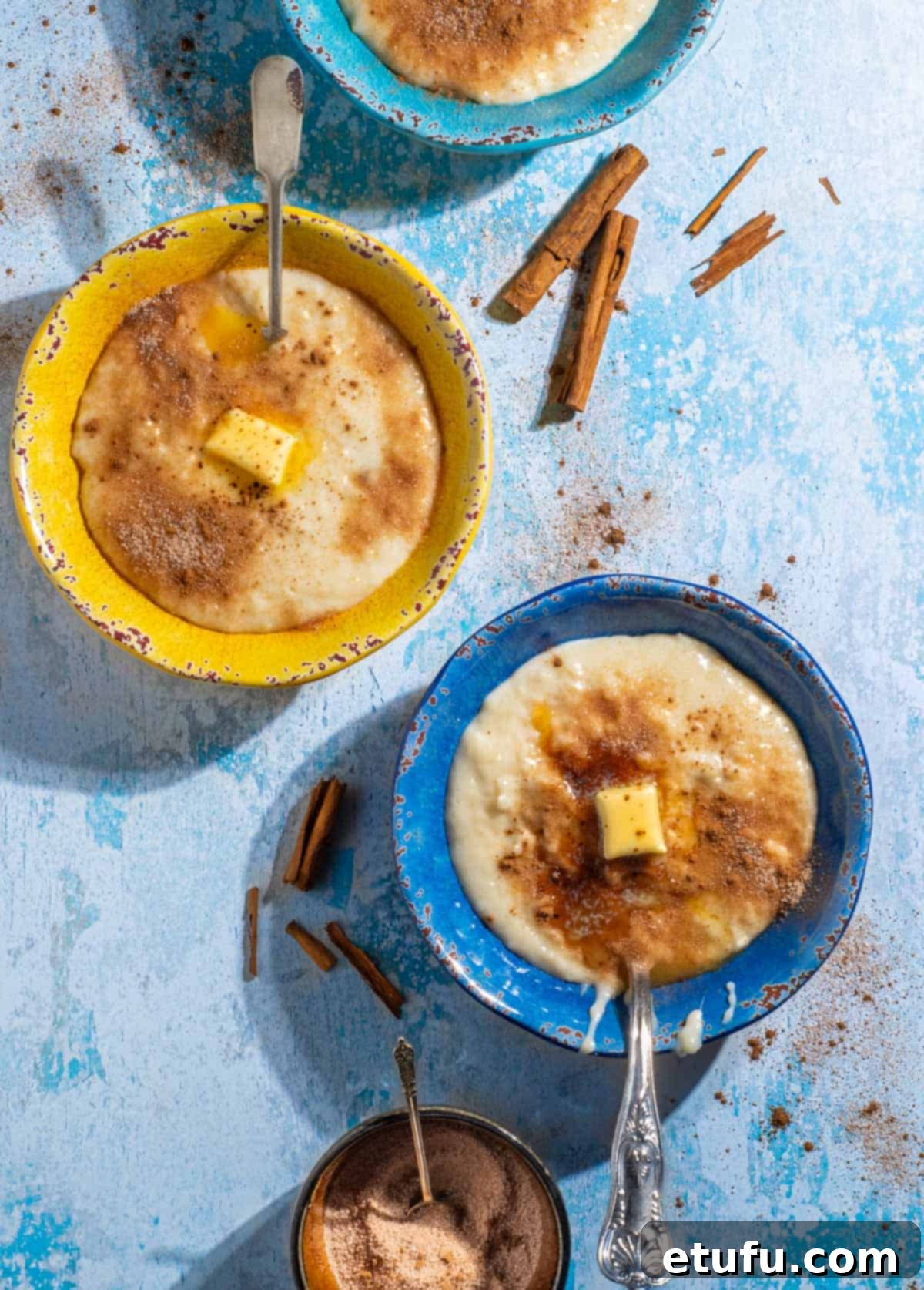 Three bowls of Melkkos, a traditional South African creamy milk dish, on a blue background, invitingly prepared with cinnamon sugar and butter.