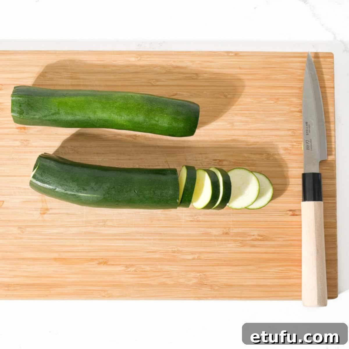 Crispy Fried Zucchini 4 Two courgettes on a chopping board with one being sliced into thick rings.