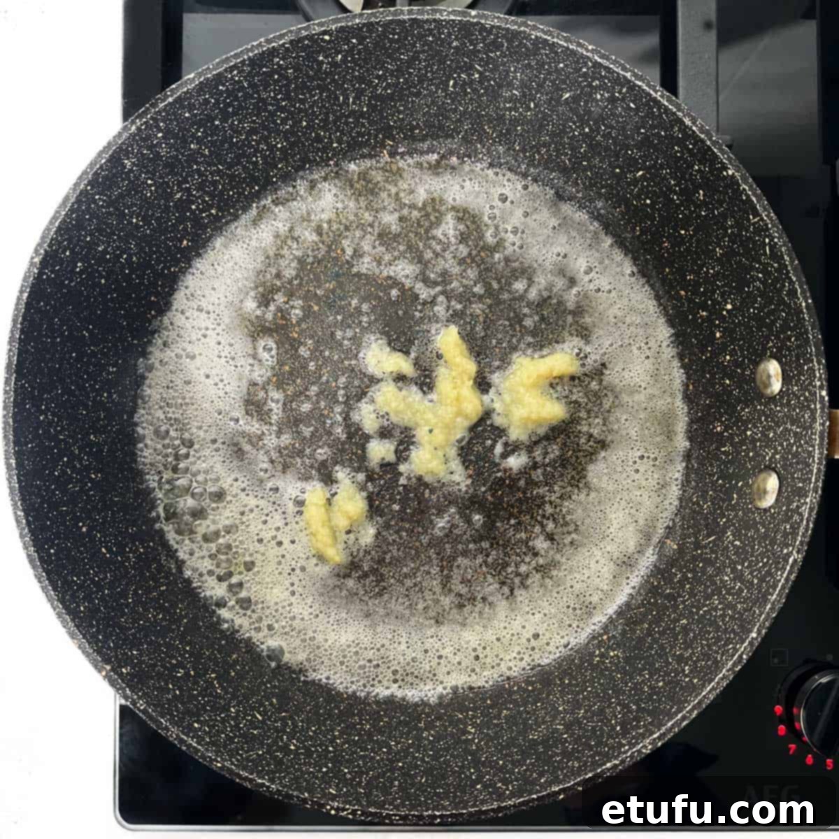 Crispy Fried Zucchini 7 Frying minced garlic in a pan with butter and oil.