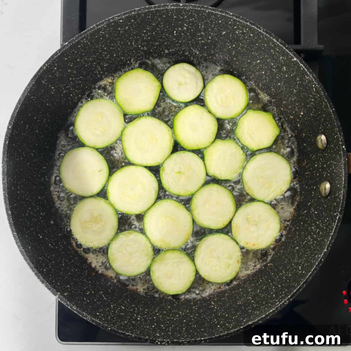 Crispy Fried Zucchini 8 Adding a single layer of courgette slices to hot butter and oil in a frying pan.