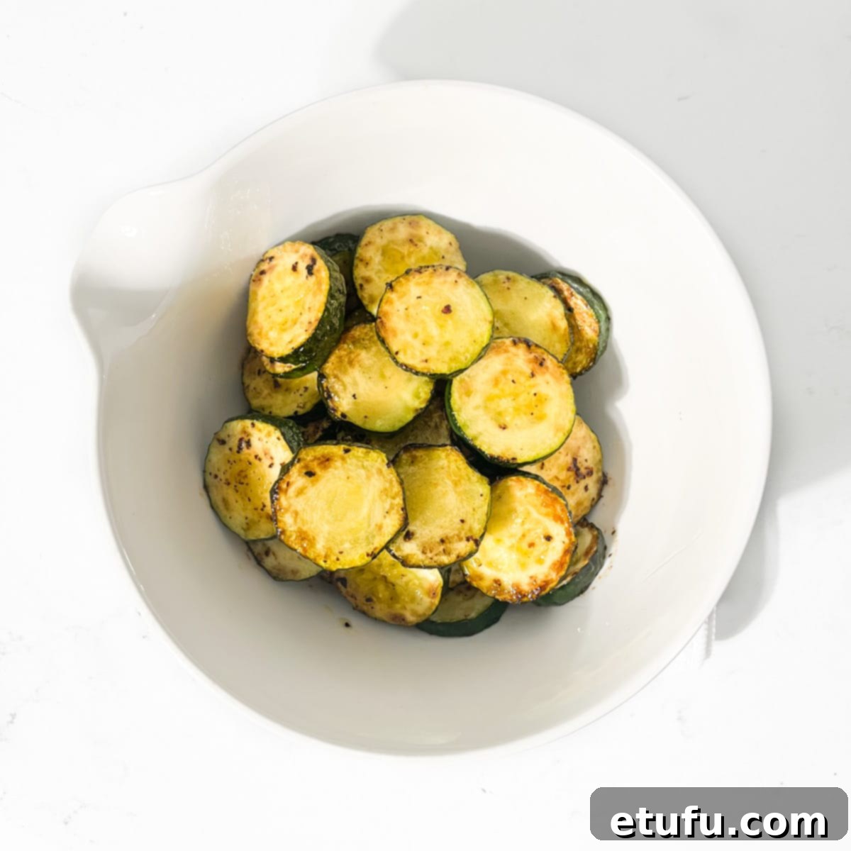Crispy Fried Zucchini 10 Fried courgettes in a white bowl, ready for seasoning.