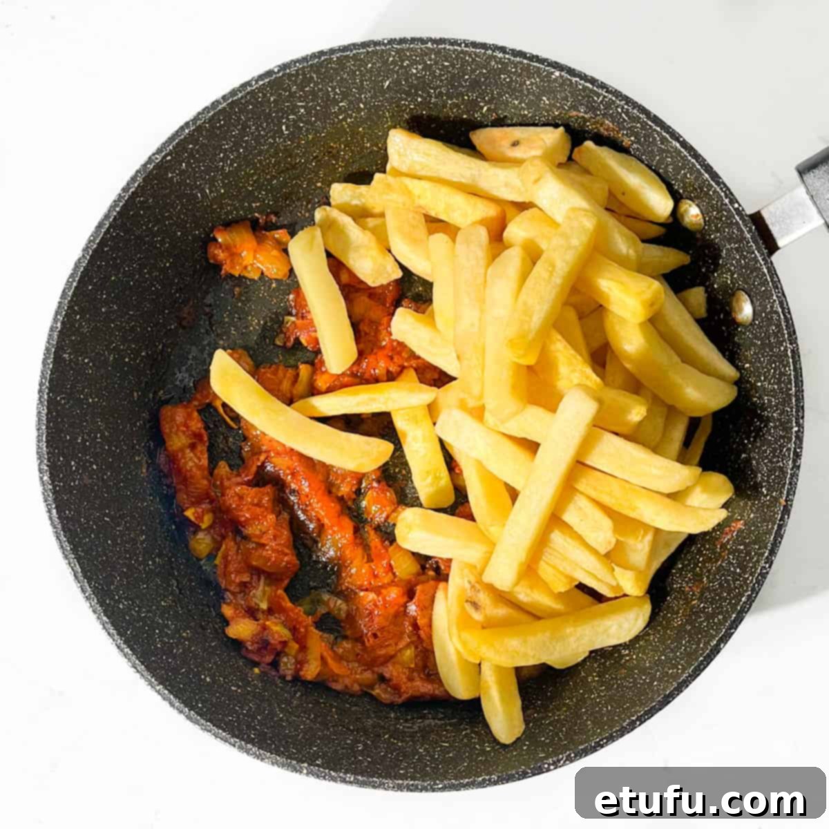 Oven chips tipped into the frying pan with the masala chips sauce.