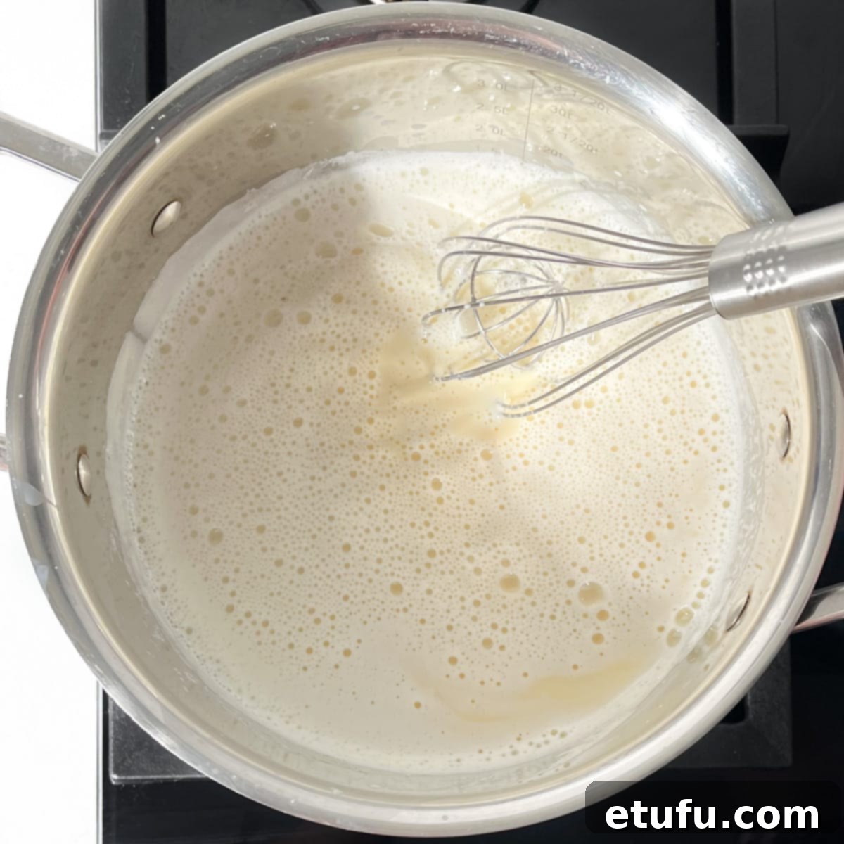 Crème Pâtissière being whisked on the stovetop with a wire whisk.