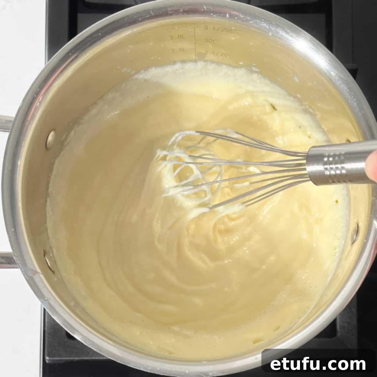 Whisking the Crème Pâtissière on the stovetop with a wire whisk.