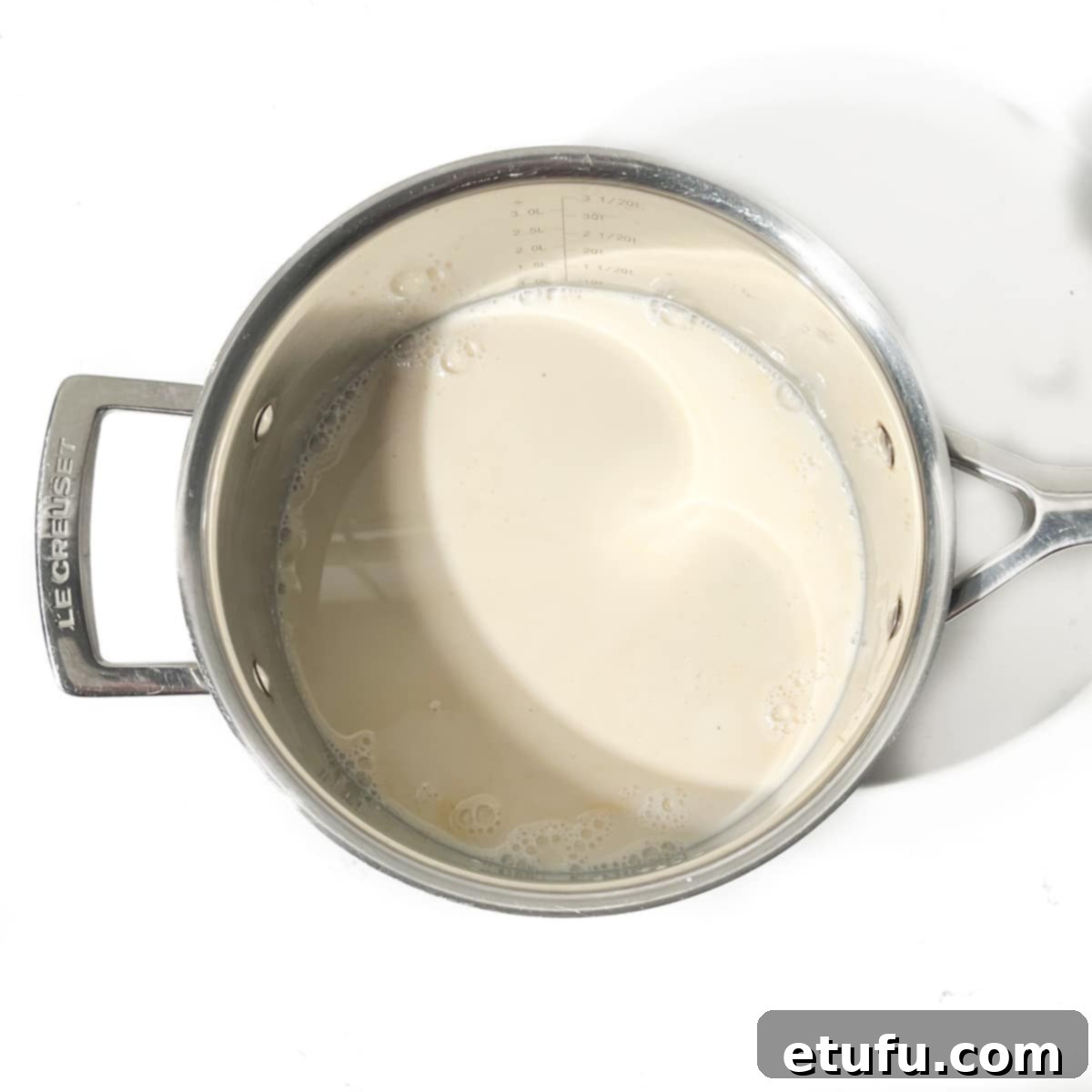 A saucepan containing milk and vanilla extract. 