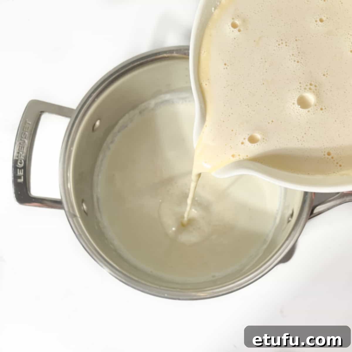 Adding the milk mixture back into the saucepan.