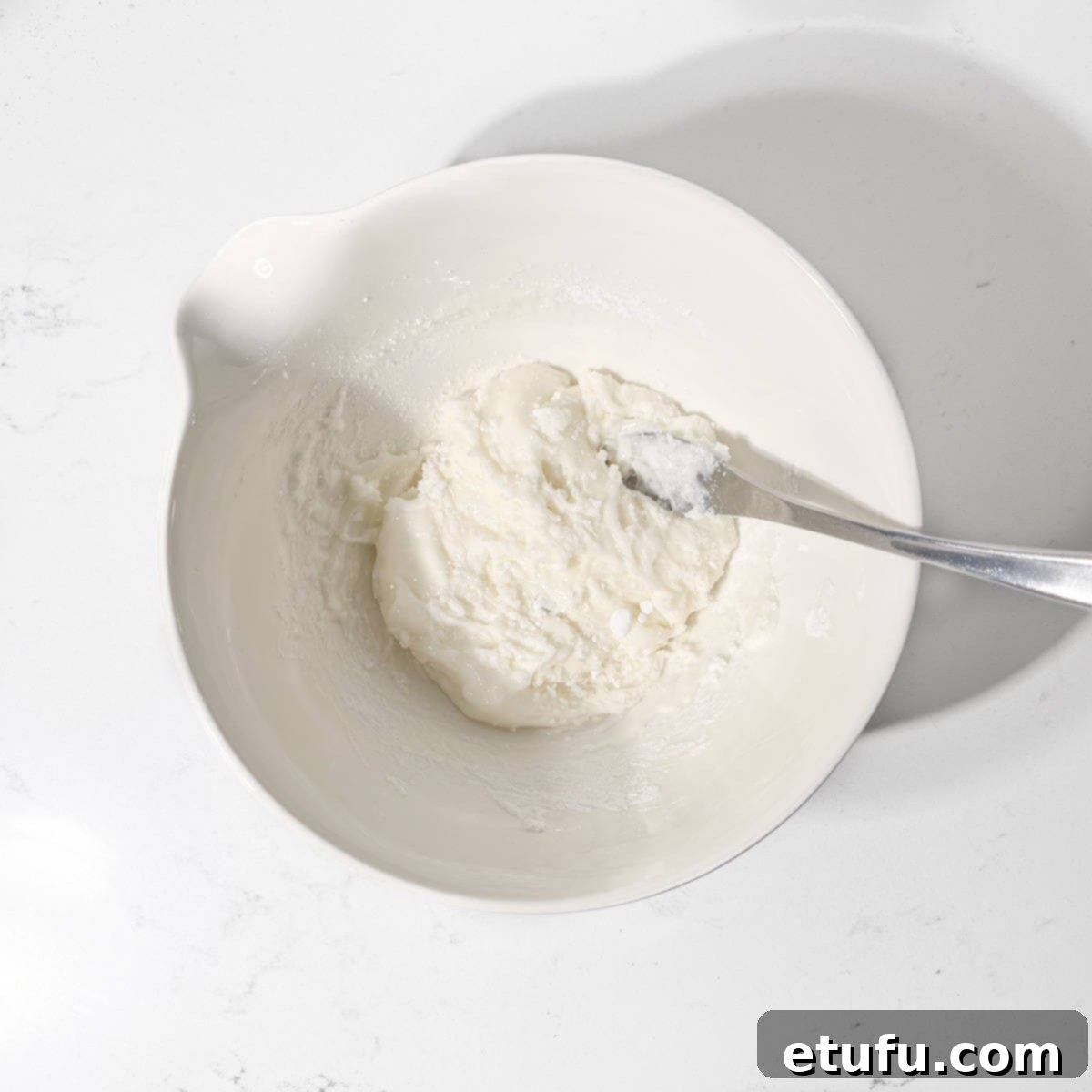 Hand-mixing the egg white into the icing sugar with a fork.