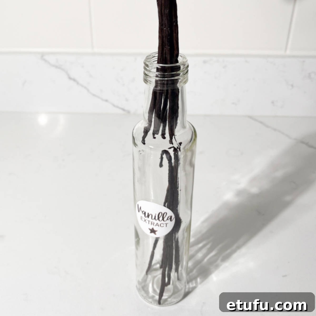 Adding vanilla pods to a glass bottle.