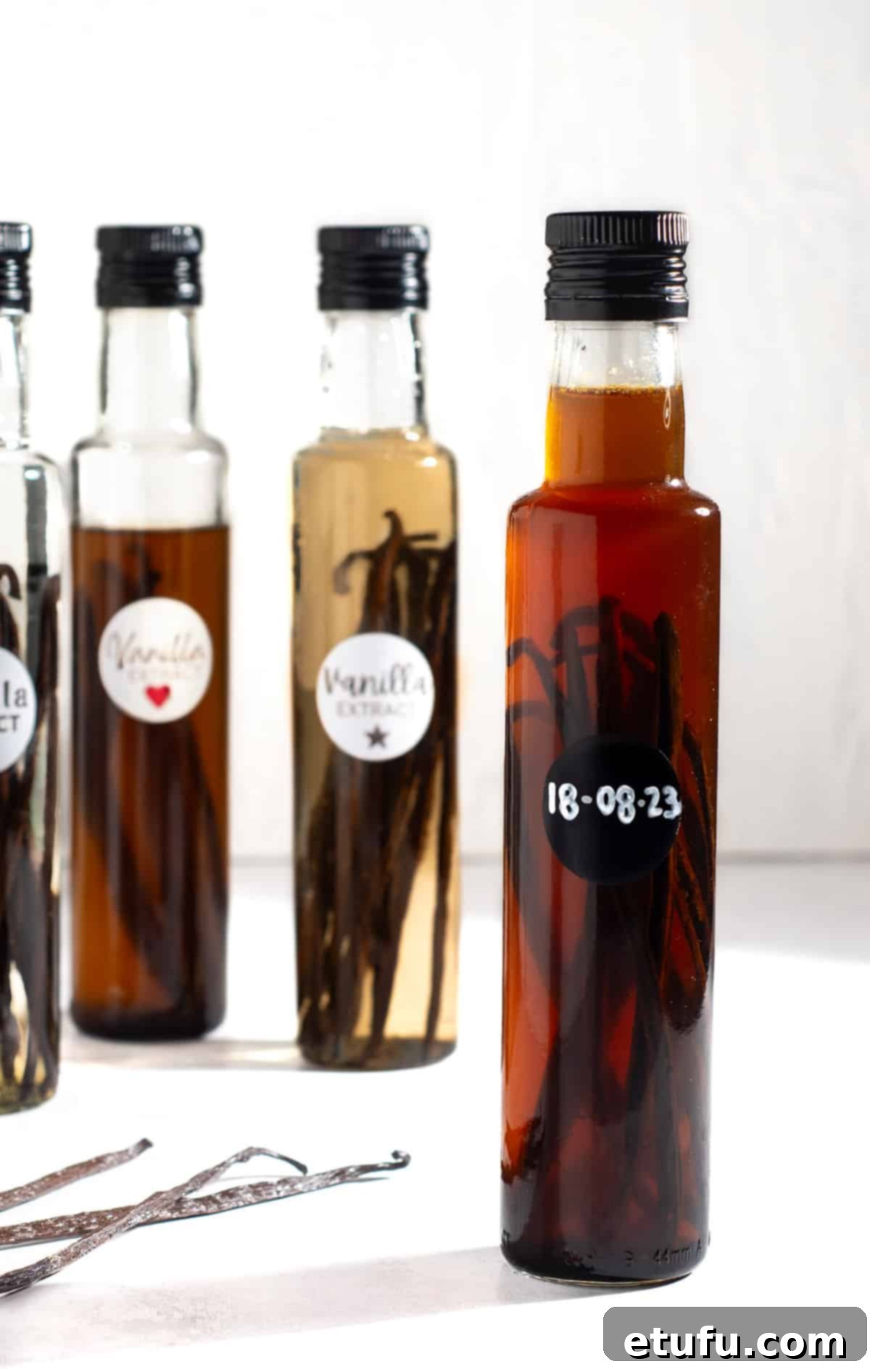 A collection of homemade vanilla extract bottles, some with labels.