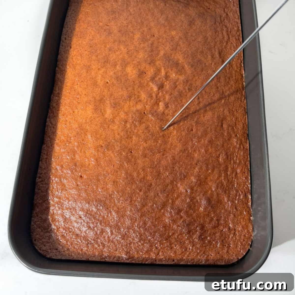 Sticky South African Malva Delight 14 Poking holes in the baked malva pudding.