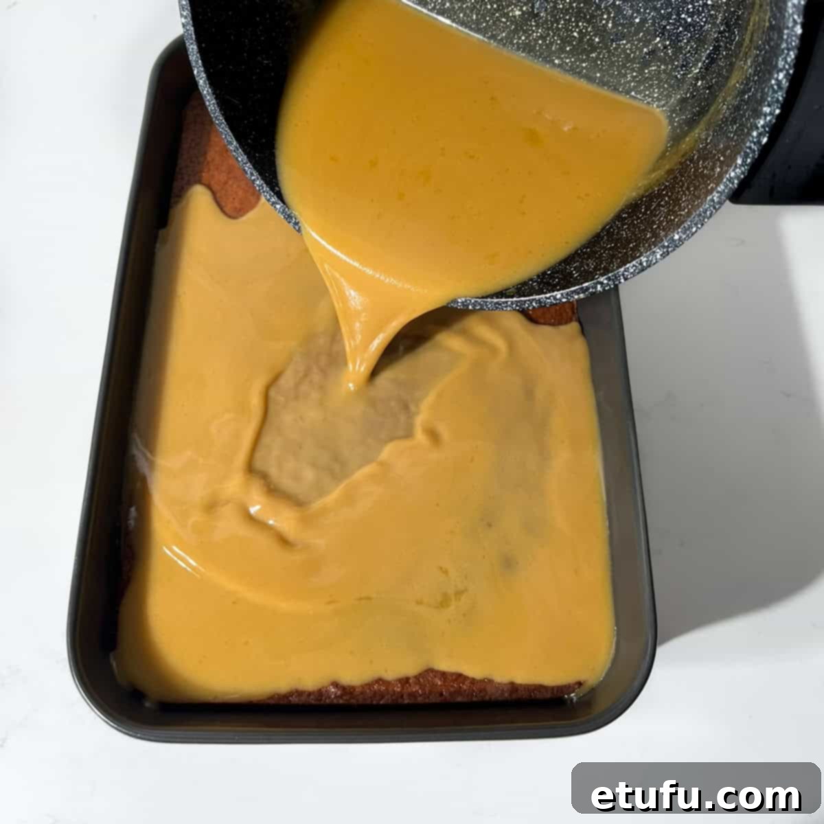 Sticky South African Malva Delight 15 Pouring the cream sauce over the hot malva pudding.