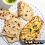 Two-ingredient flatbreads beautifully arranged on a white tray, accompanied by a small bowl of fresh parsley butter.